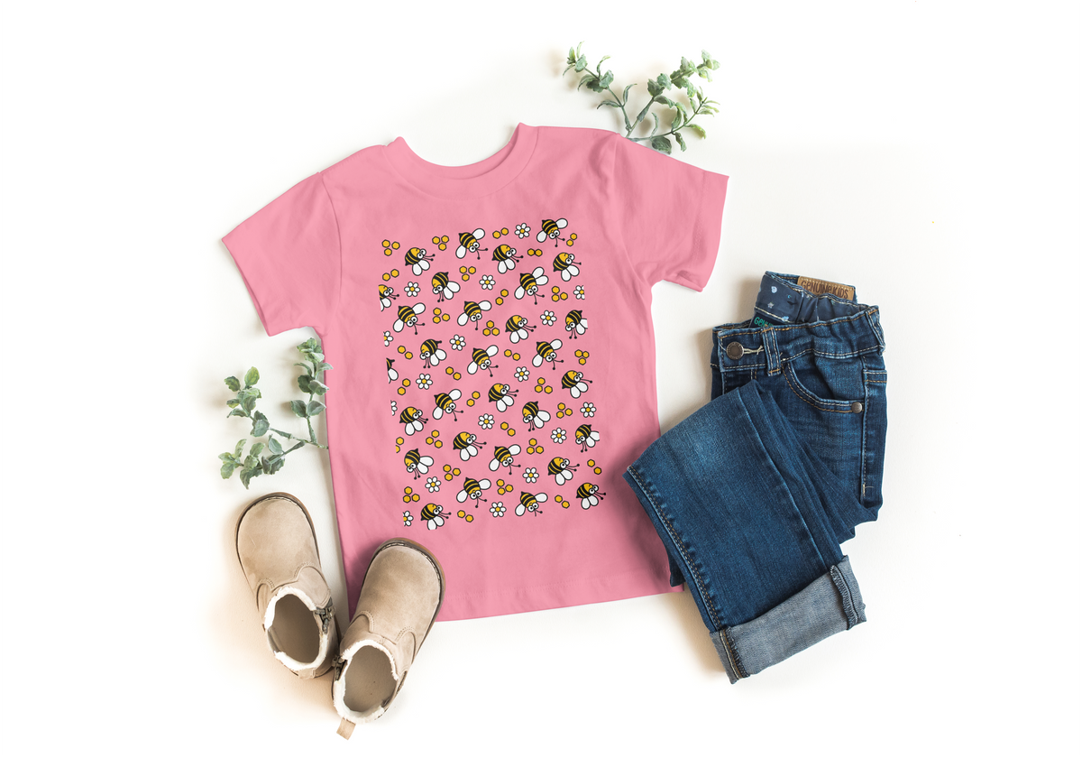 Pink kids t-shirt with all-over flying bees and daisy print, styled with jeans and boots - Marfz.pk