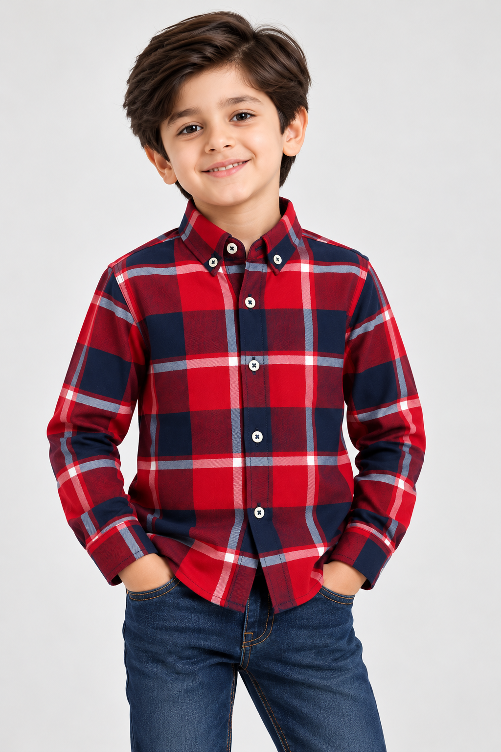 Boy wearing a red and navy blue checked flannel shirt with long sleeves and button-down collar, styled with blue jeans.