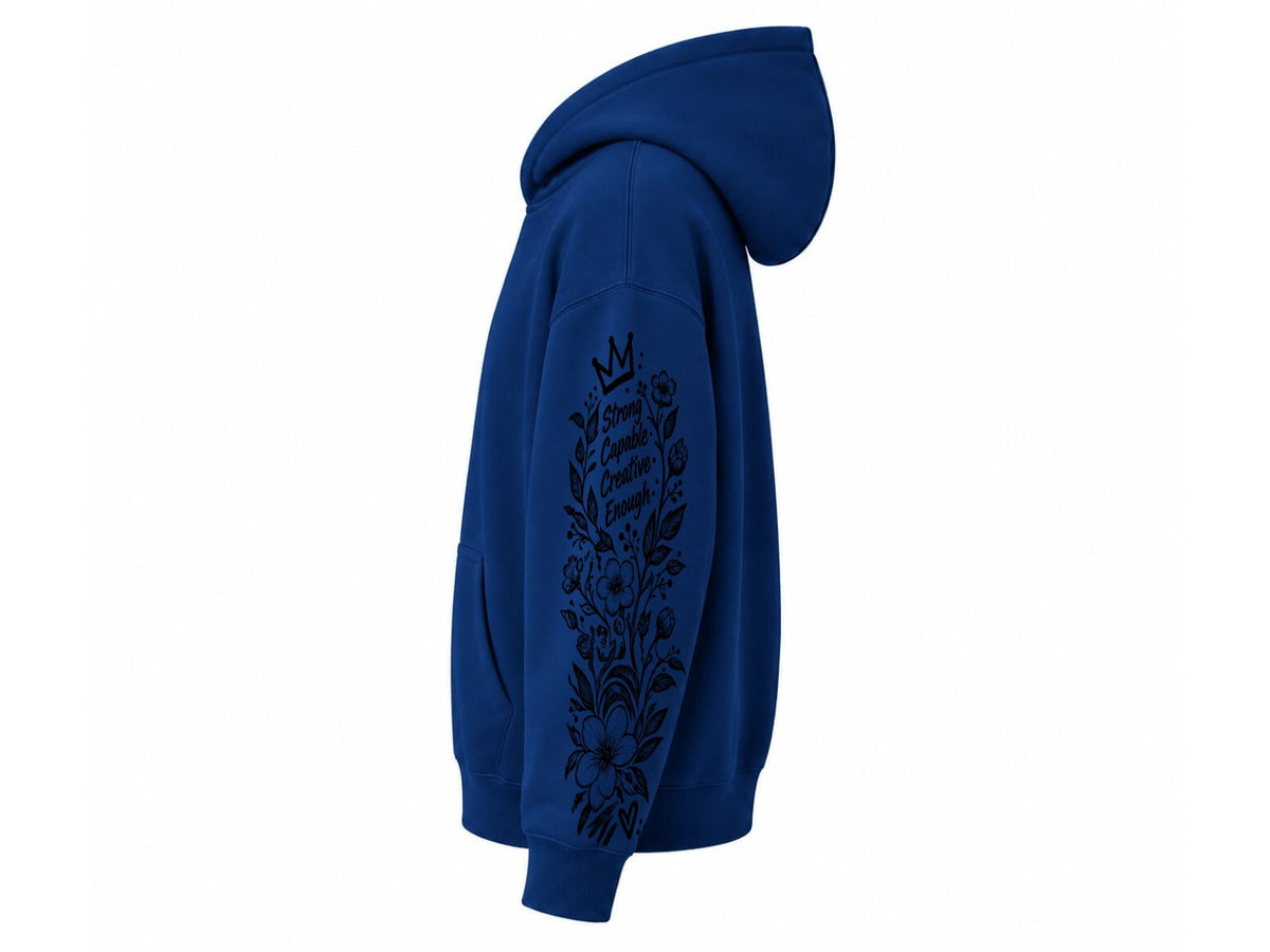 A royal blue pullover hoodie shown from the side profile, featuring a black floral and crown graphic printed down the right sleeve, set against a plain white background.