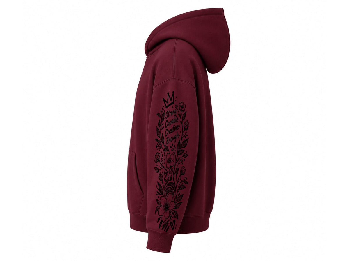 A maroon pullover hoodie shown from the side profile on a plain white background, featuring a black floral graphic and crown design printed down the right sleeve.