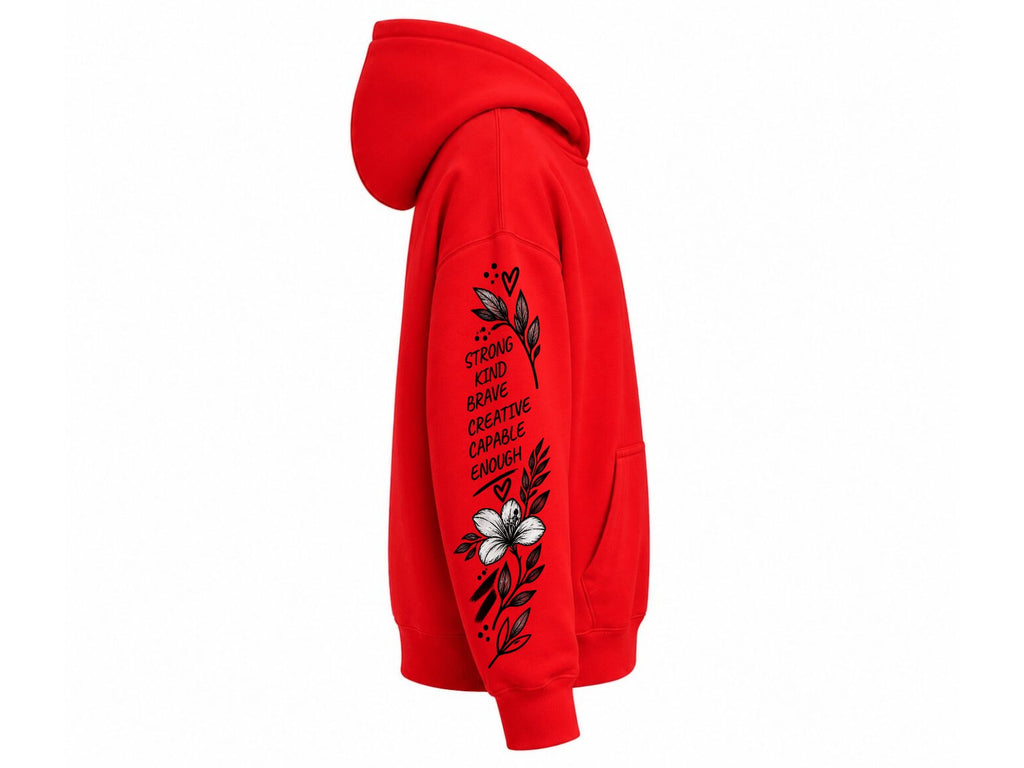 A bright red pullover hoodie shown from the side profile on a plain white background. The right sleeve features a black graphic with the text 'STRENGTH AND BRAVE CREATIVE ENOUGH' alongside a black floral design and a white flower near the bottom.